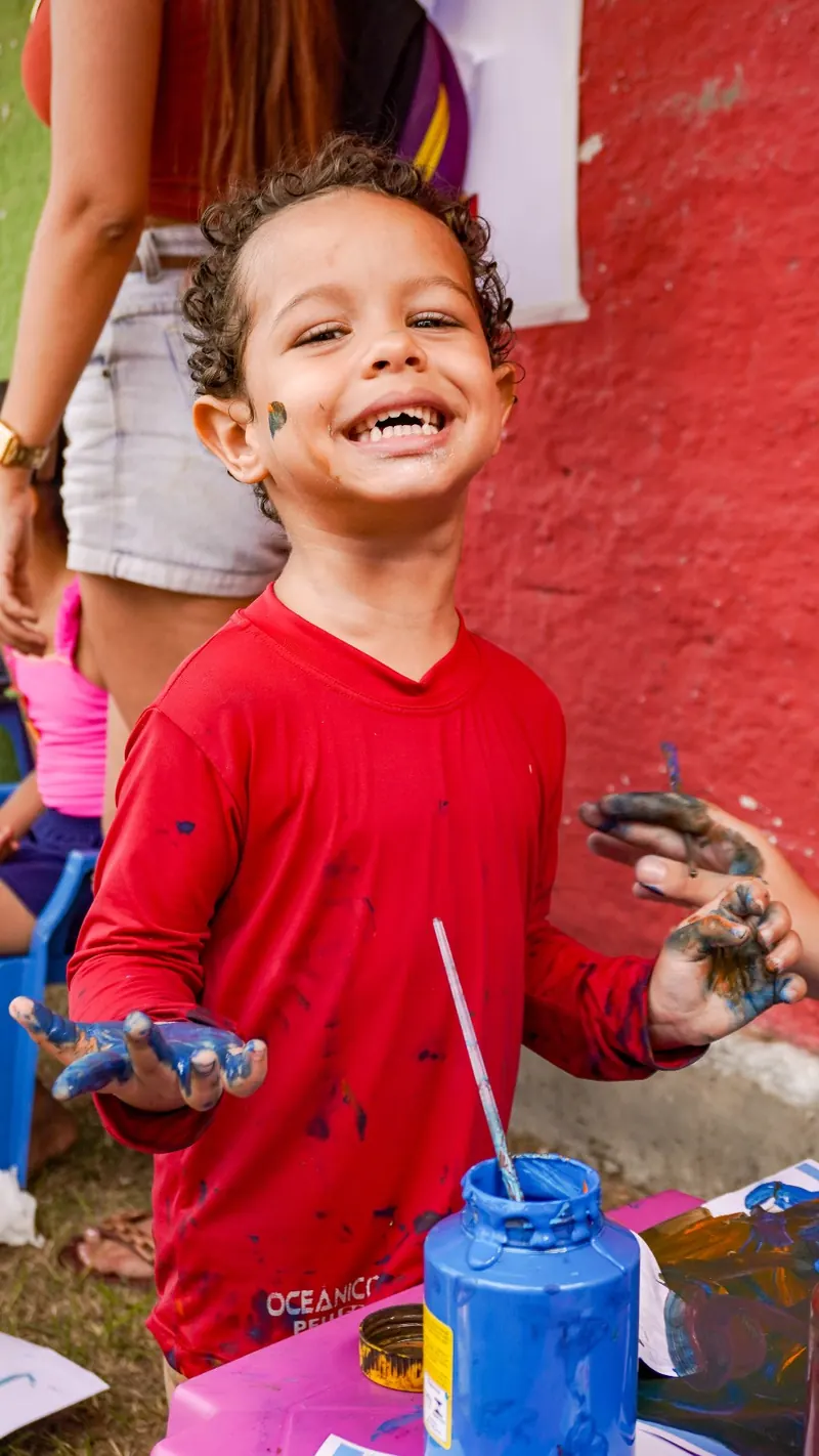 Criança sorrindo durante atividade esportiva do Time da Inclusão